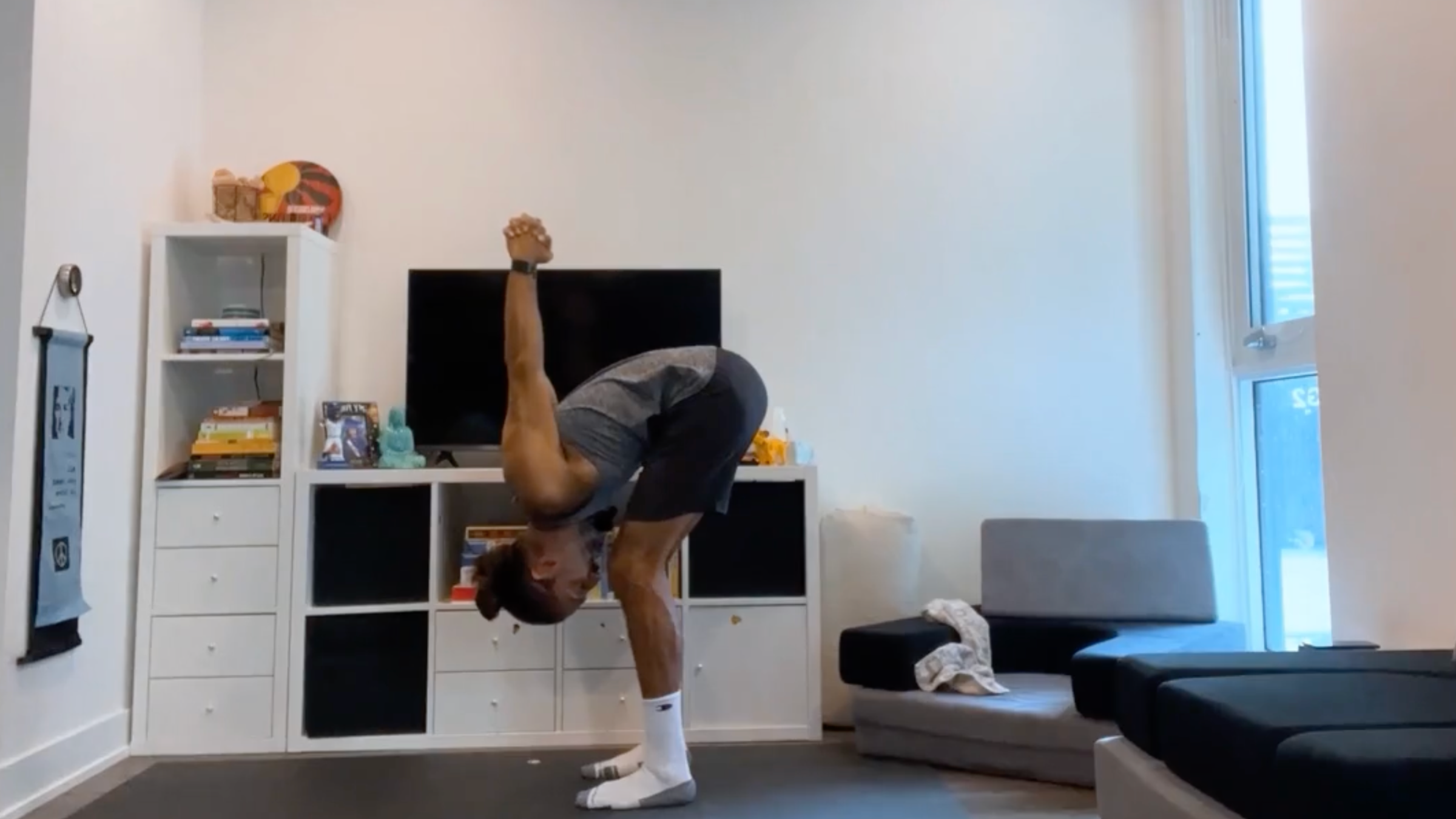 Teacher Jaffer Hussain in a variation of Standing Forward Bend, Uttanasana in Sanskrit